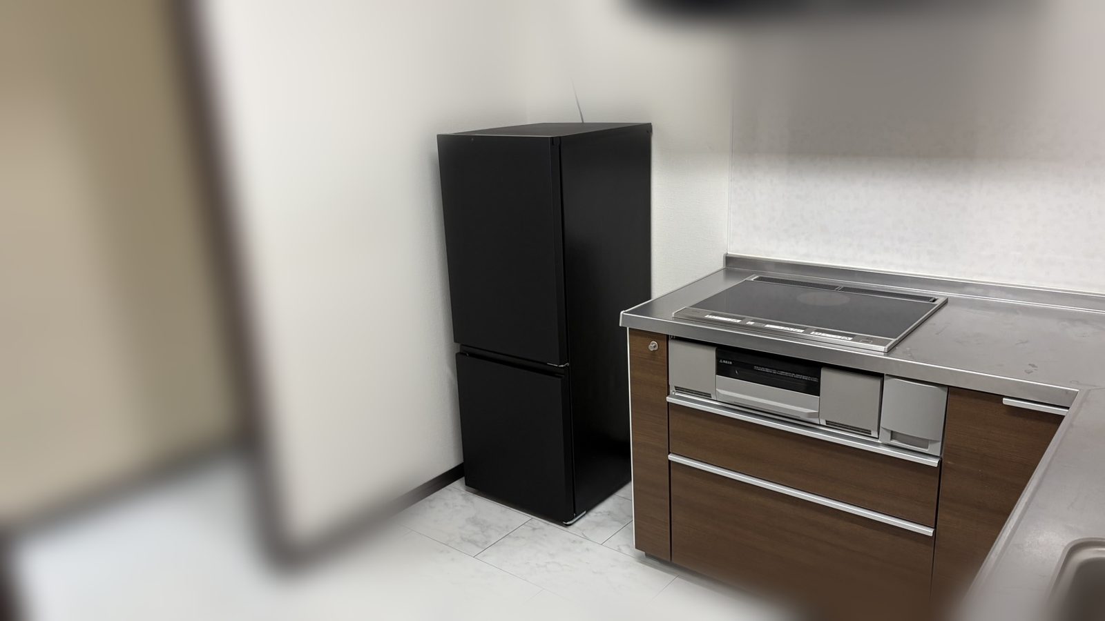 Kitchen corner with a black fridge in Room 303