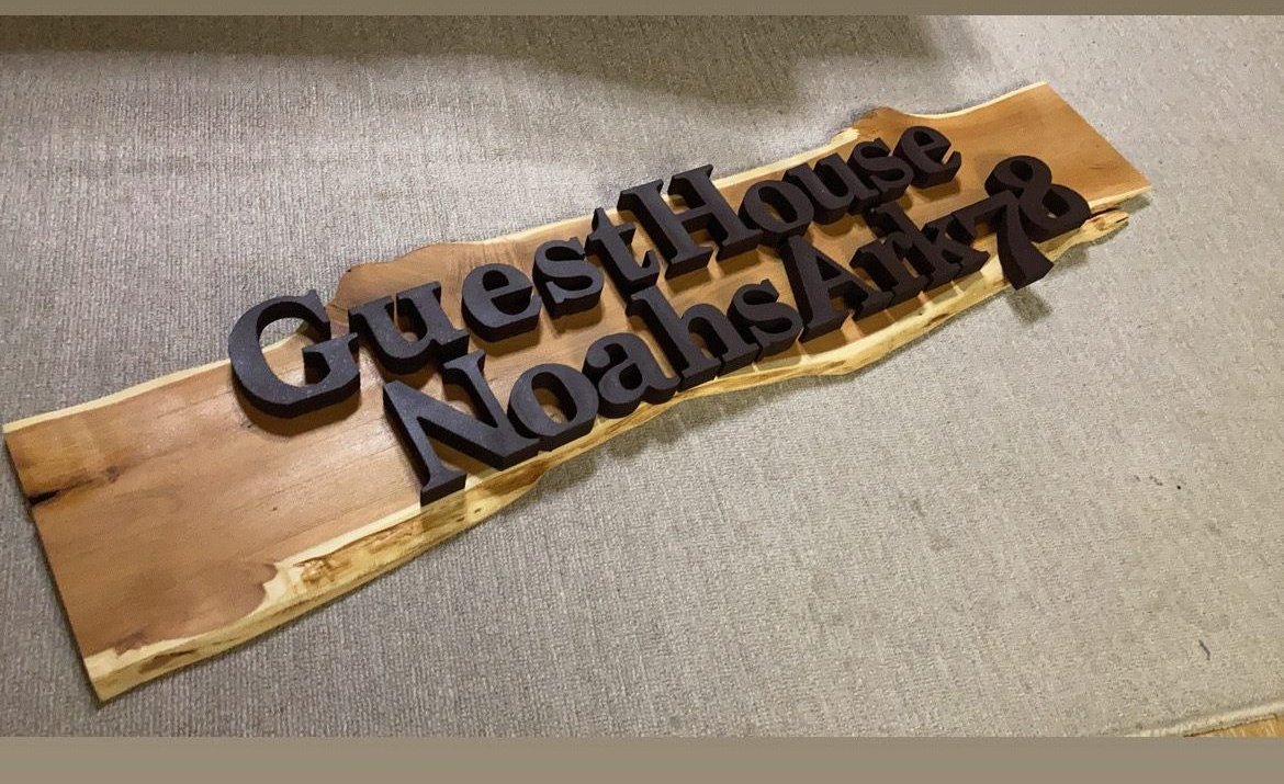 Carved wooden The Guesthouse Noah signboard