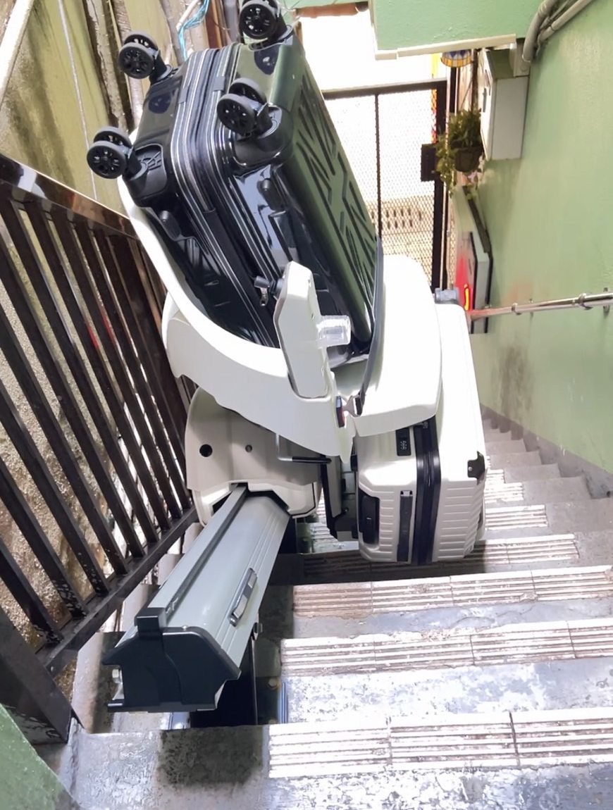 Powered stair lift carrying suitcases up the staircase